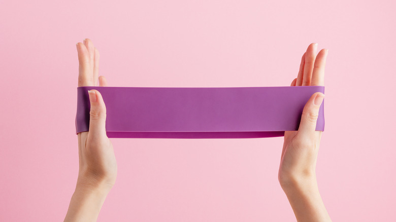 A giant rubber band being stretched in a pair of hands