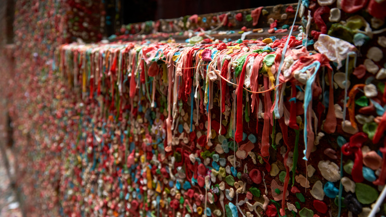 Thousands of wads of chewed gum stuck to a brick wall