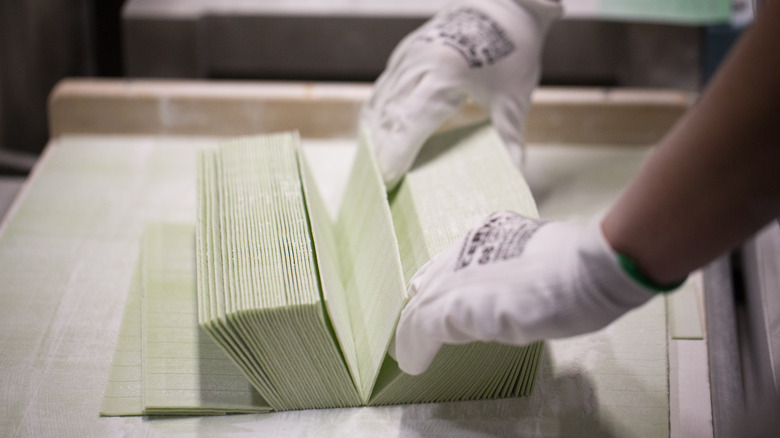 A factory worker handling strips of gum 