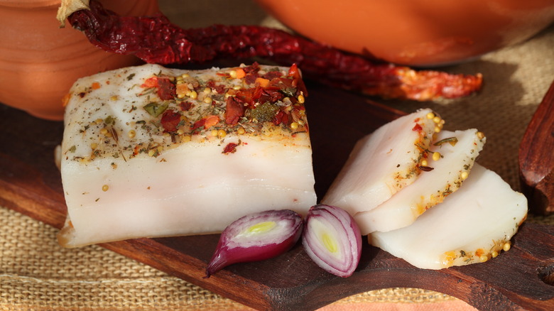 Lardo and spices on a wooden cutting board