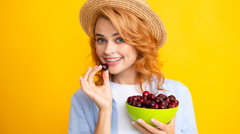 Girl eating cherries from a bowl