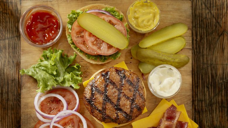 burger with condiments spread out