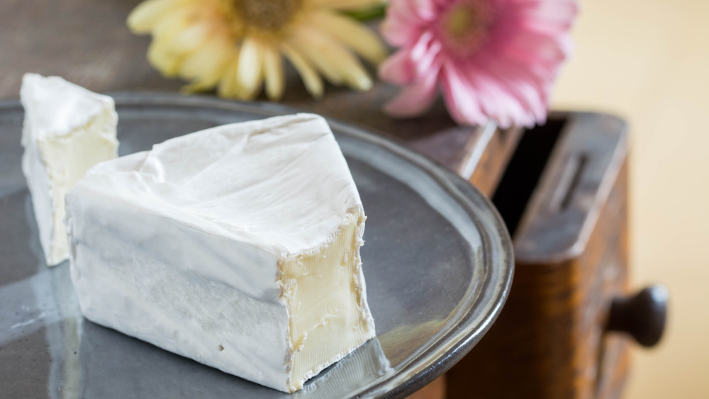 slicing a soft cheese wedge 