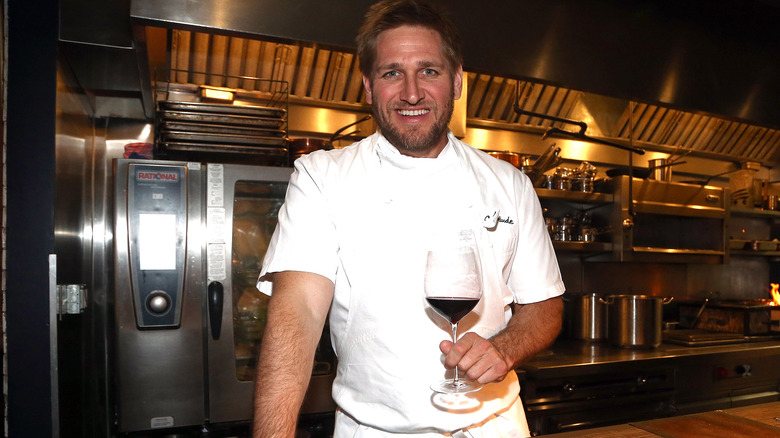 Curtis Stone holding wine glass at Maude