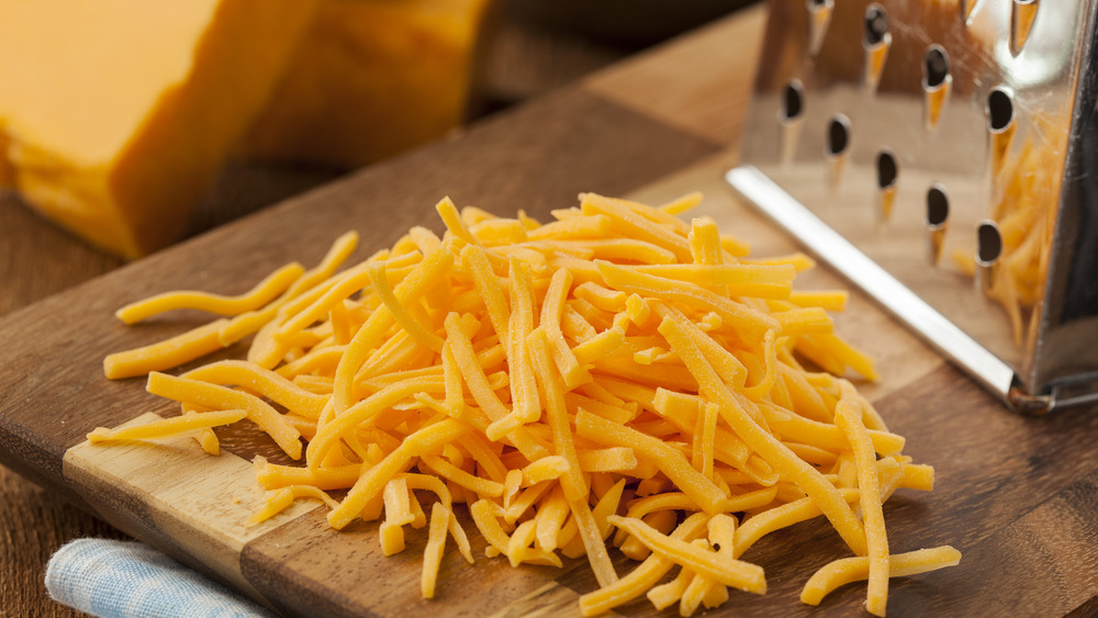 shredded cheddar cheese next to a cheese grater