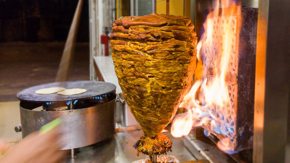 Al pastor being roasted on a trompo