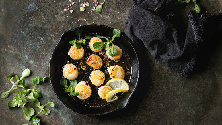 Scallops searing in a cast iron pan