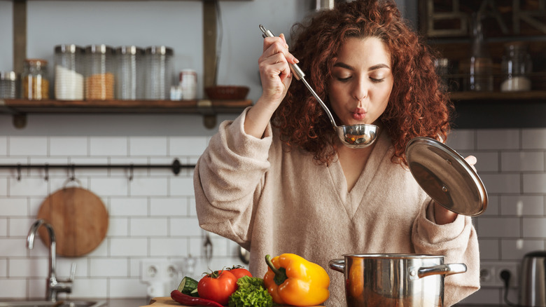 Woman tasting soup from a ladle