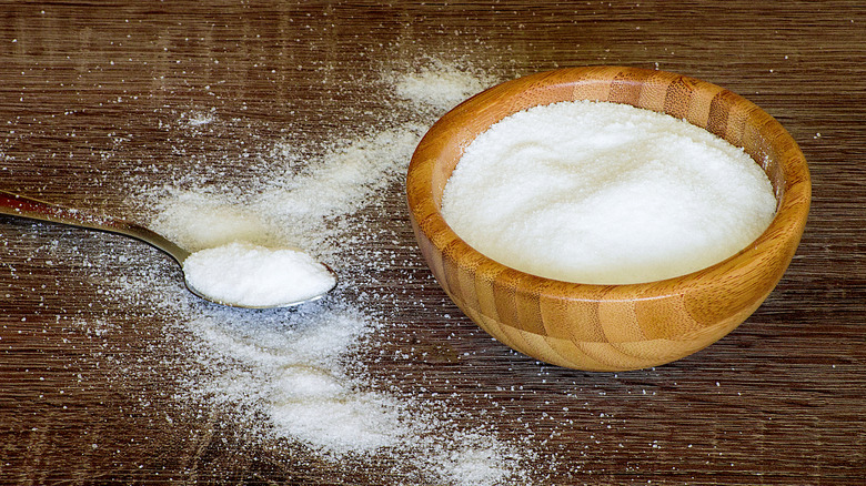 wooden bowl of salt with metal spoon