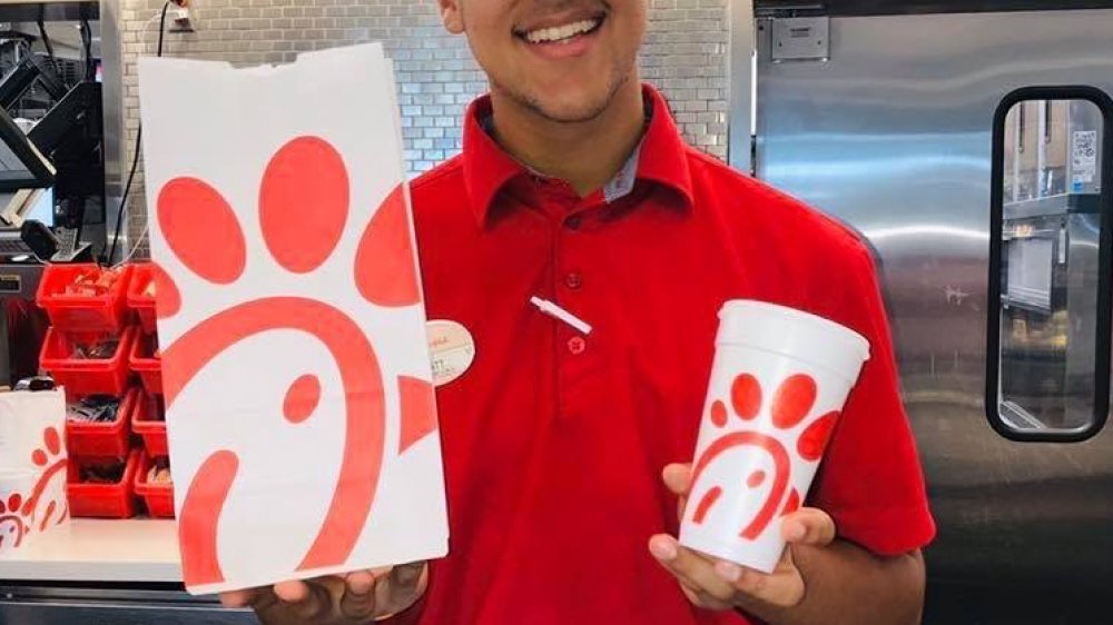 Chick-fil-A worker smiling handing over food