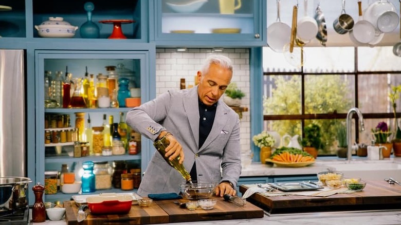 Geoffrey Zakarian adding olive oil to a bowl