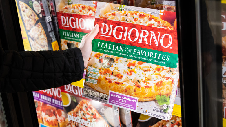 Person grabbing a DiGiorno frozen pizza 