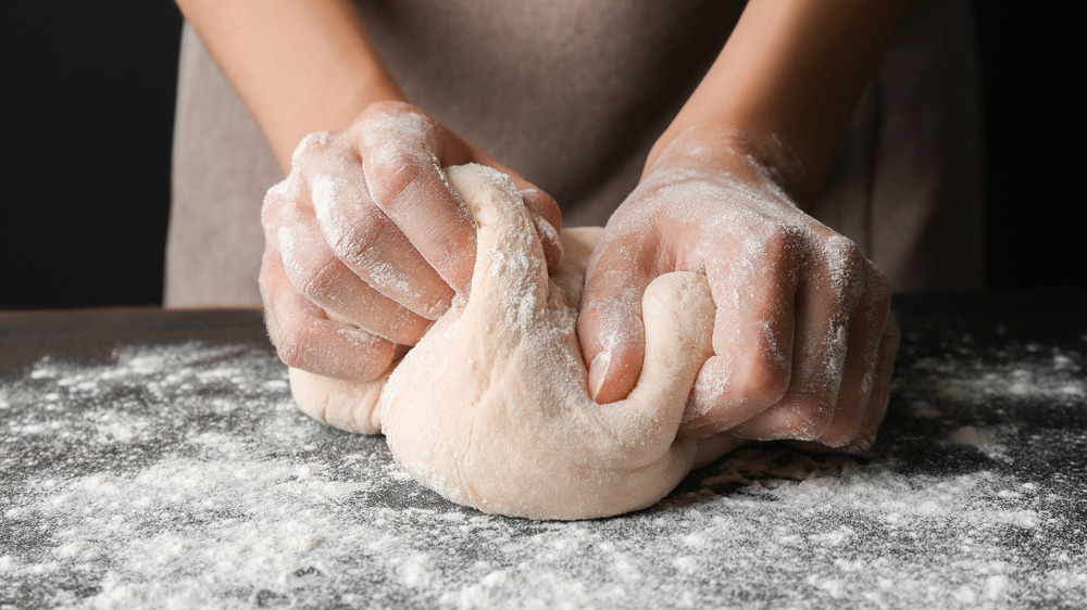 Hands kneading pizza dough