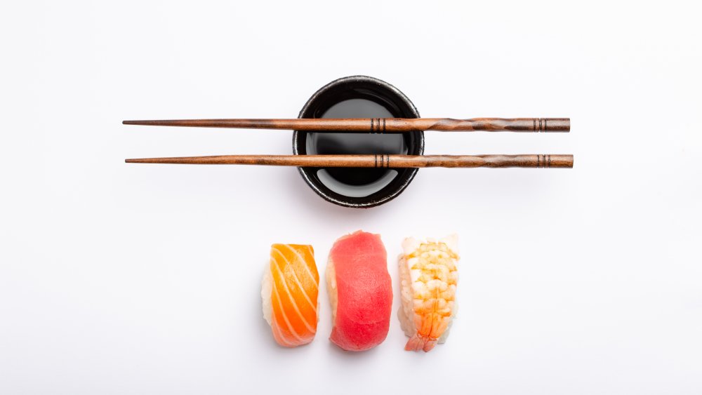 three pieces of sushi next to soy sauce