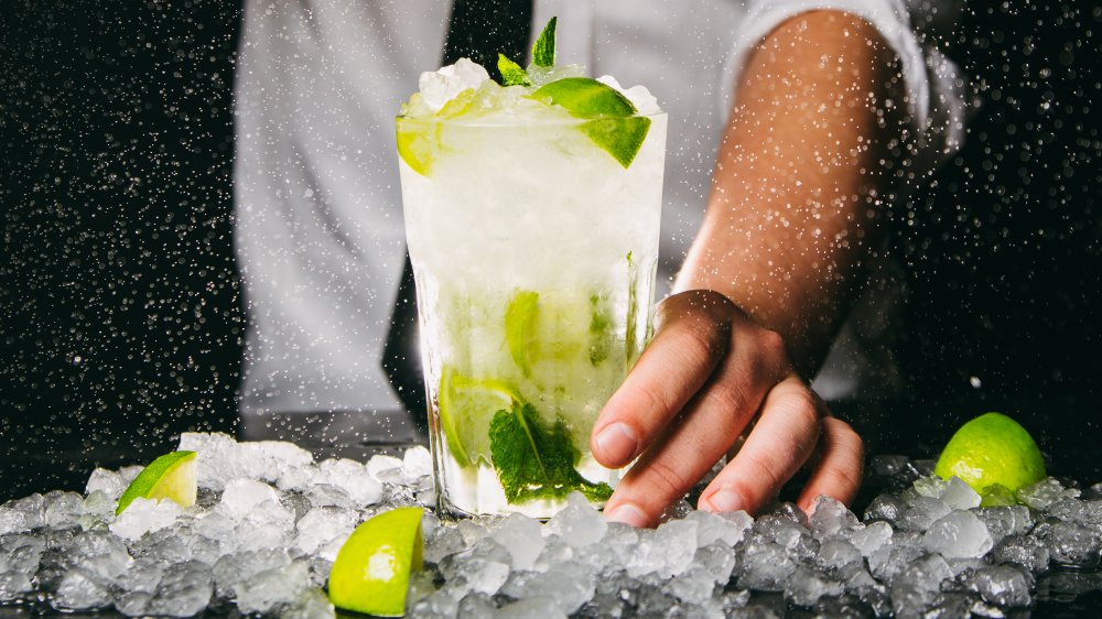 Bartender serving a mojito with crushed ice and lime