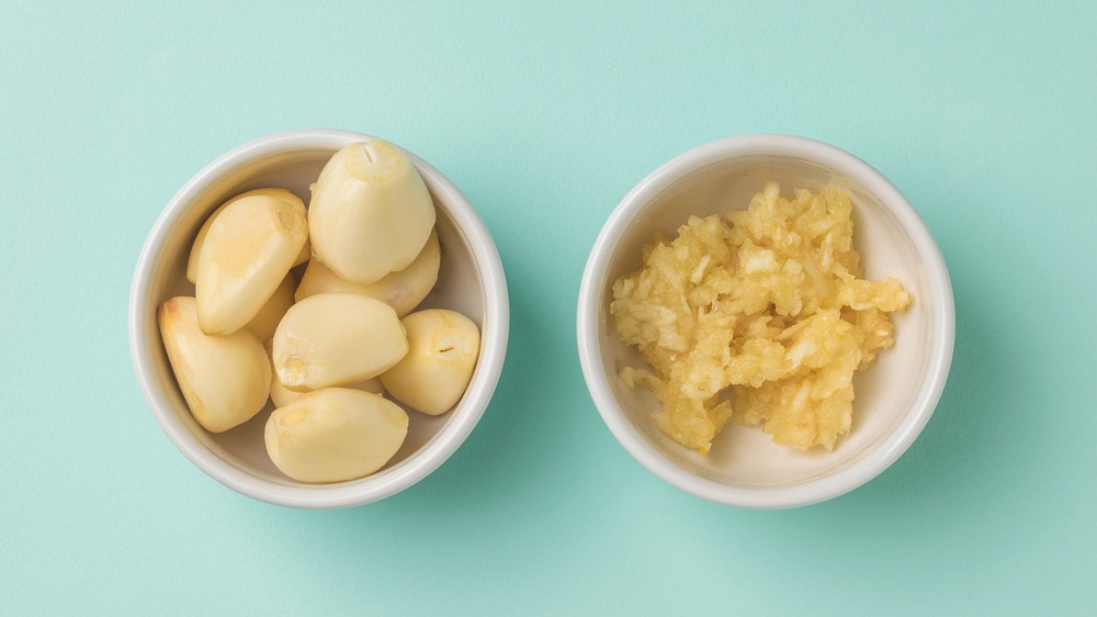 A bowl of garlic cloves and a bowl of garlic paste