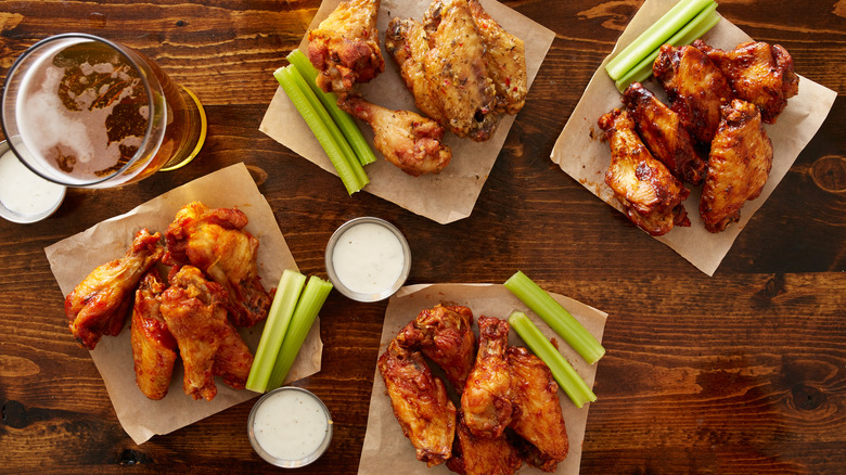 Buffalo wings served on paper with celery and dip