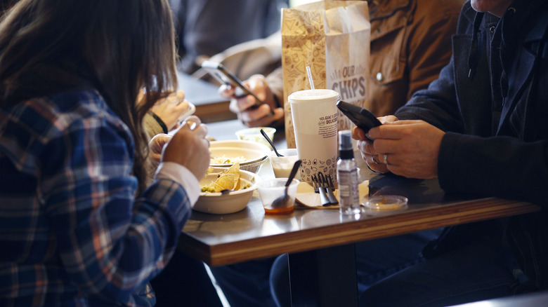 two people sitting and eating at Chipotle