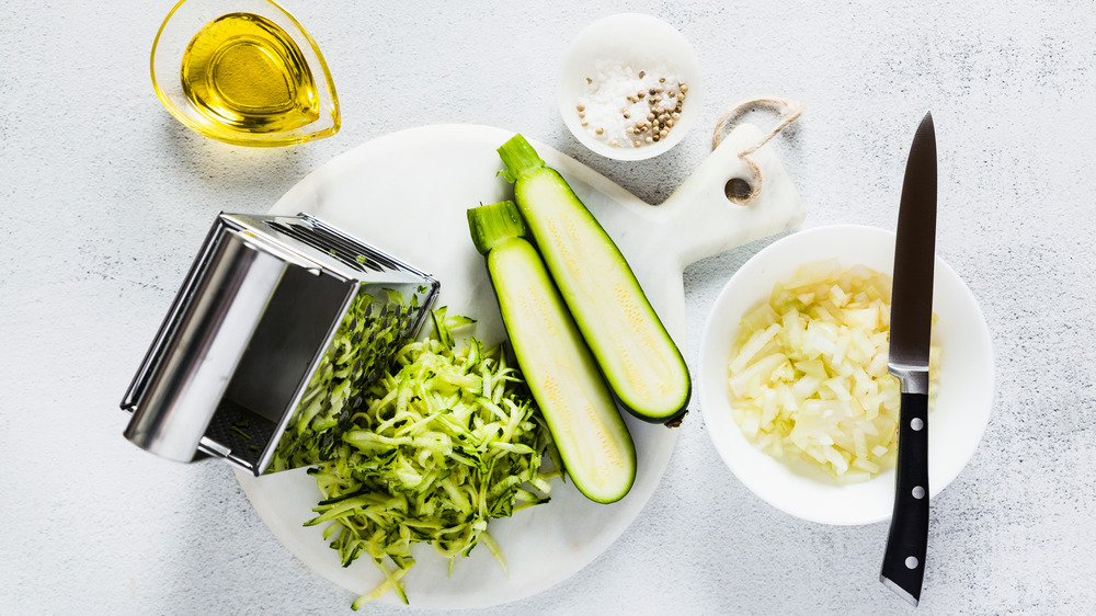 A box grater next to zucchini