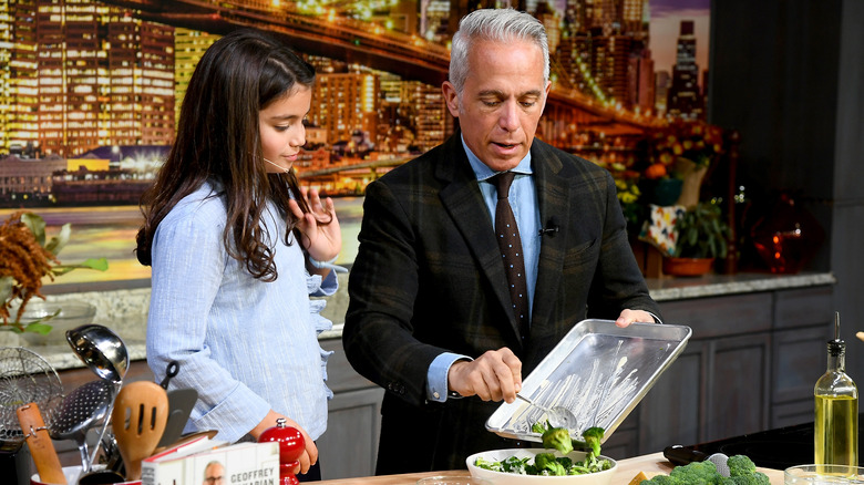 Geoffrey Zakarian scraping broccoli off a pan