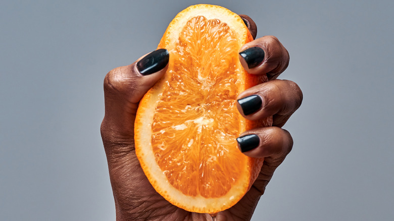Hand crushing orange