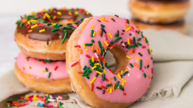 three donuts with icing and rainbow sprinkles