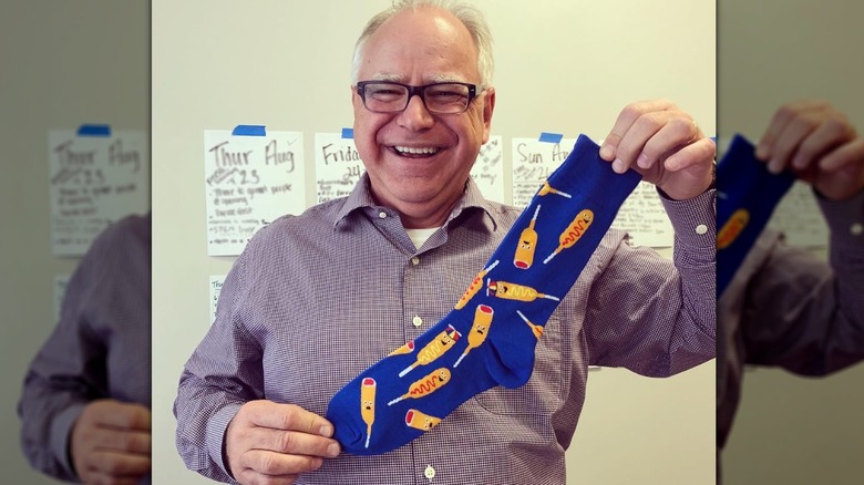 Tim Walz smiling holding corn dog socks