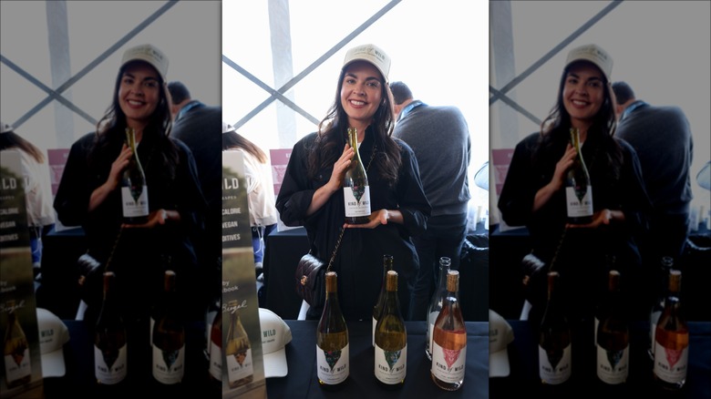 Katie Lee posing with wines from her brand