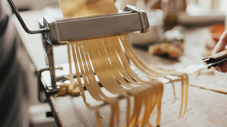 Homemade pasta threaded through pasta maker