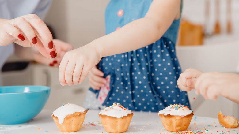 Kid helping decorate cupcakes