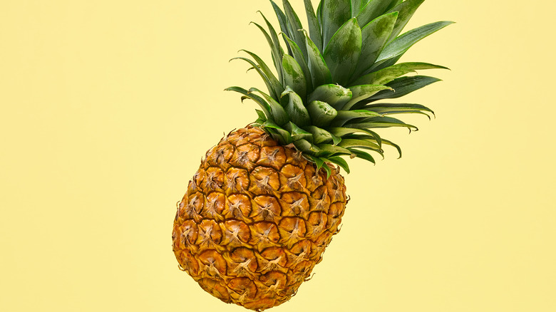 A pineapple against a yellow background