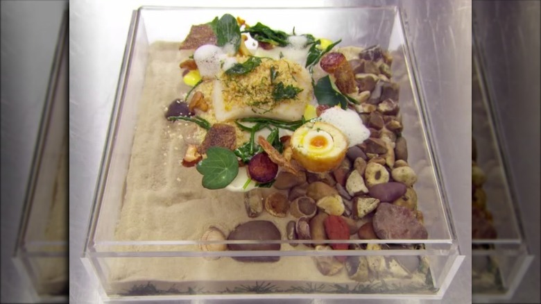 Seafood and egg on a box of rocks and sand