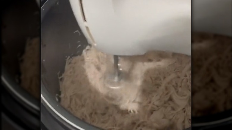 Electric mixer blending chicken