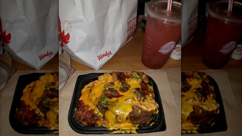 Wendy's baked potato next to bag of food and drink