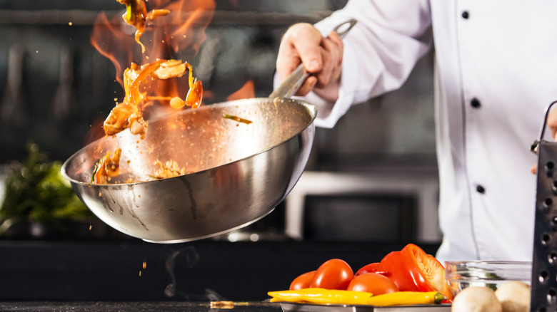 Person cooking in wok