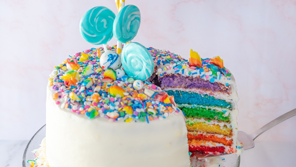 slicing a rainbow cake