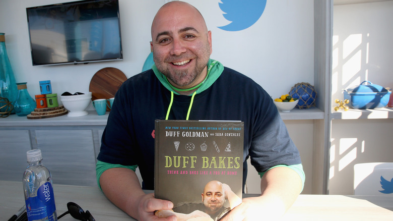 Duff Goldman holding cookbook