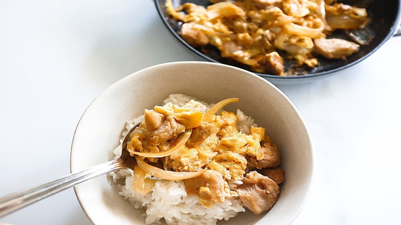 Bowl of rice partially topped with chicken