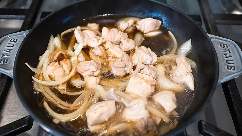 Chopped chicken and onions in saucepan