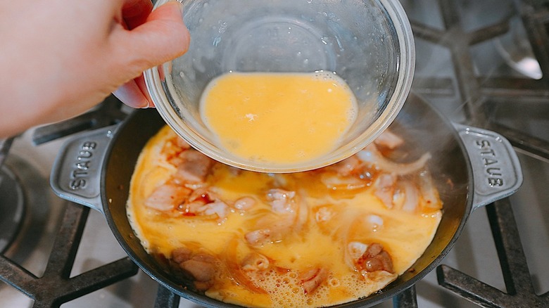 Pouring eggs into saucepan