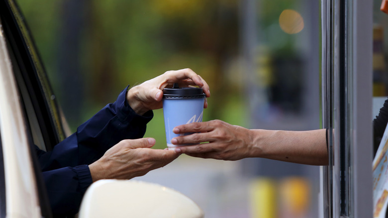 Person taking cup of coffee from McDonald's drive-thru