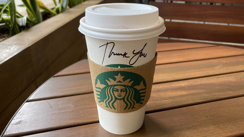 Starbucks paper cup with thank you written on it