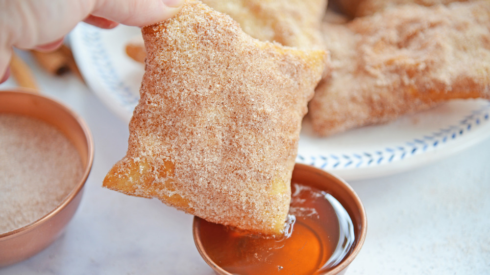 Dipping sopapilla in honey