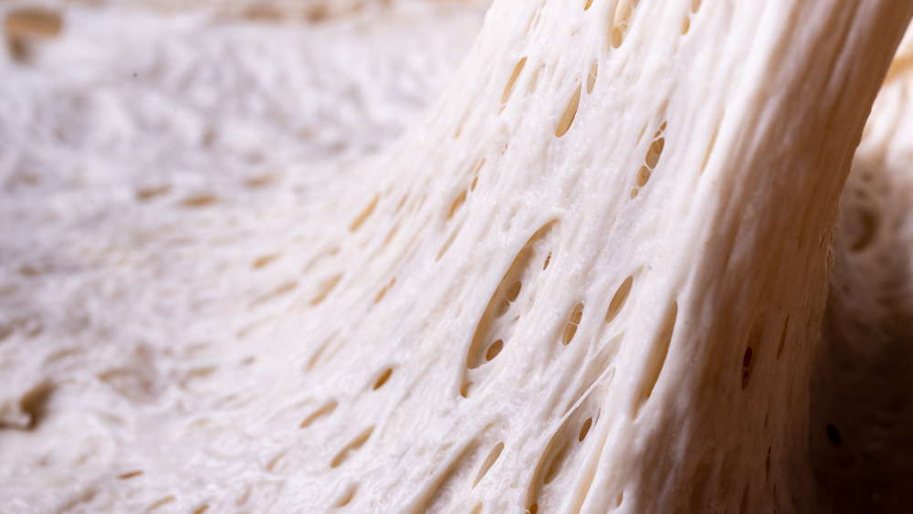 Sticky bread dough being pulled