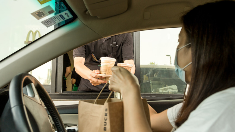 Starbucks drive-thru employee handing order to customer