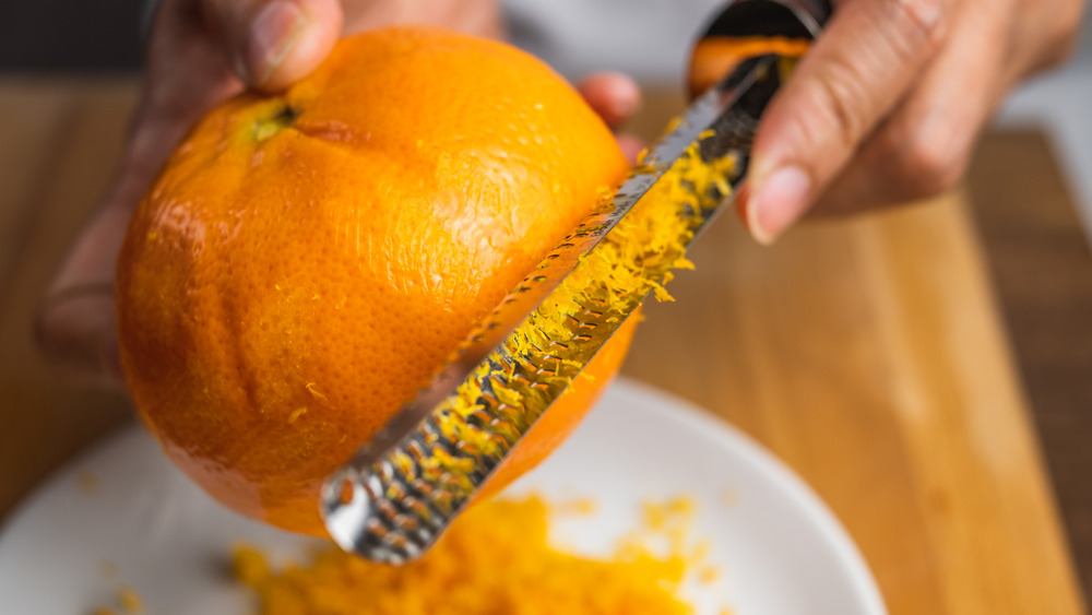 Person zesting an orange