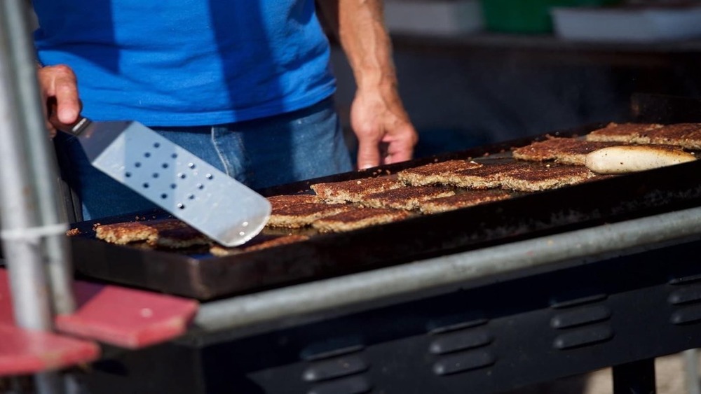 Man cooking slices of goetta