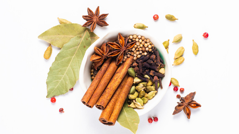 Bay leaves, cinnamon, cardamom, and other spices in bowl