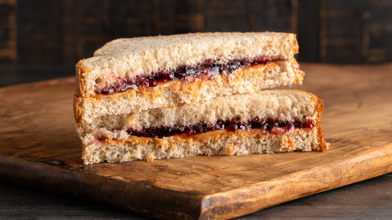 PB&J sandwich cut in half then stacked on top of each other over wooden cutting board