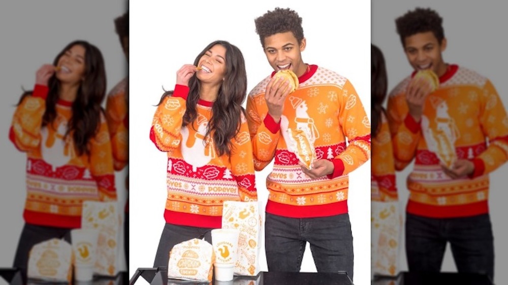 Man and women eating fast food wearing holiday sweaters